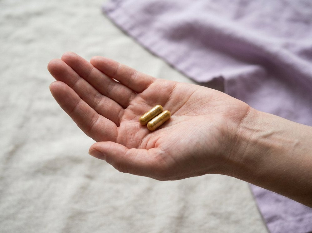Two capsules in an open palm