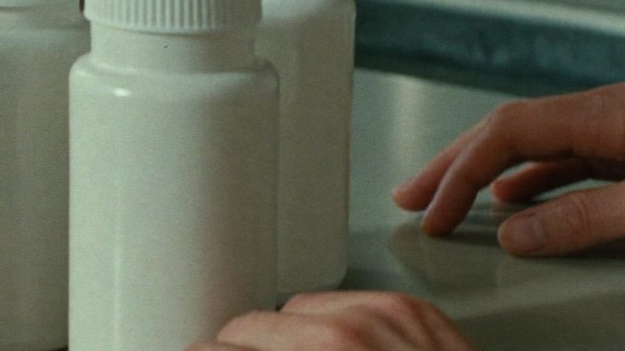 Prescription bottles and a weekly pill organiser on a kitchen counter